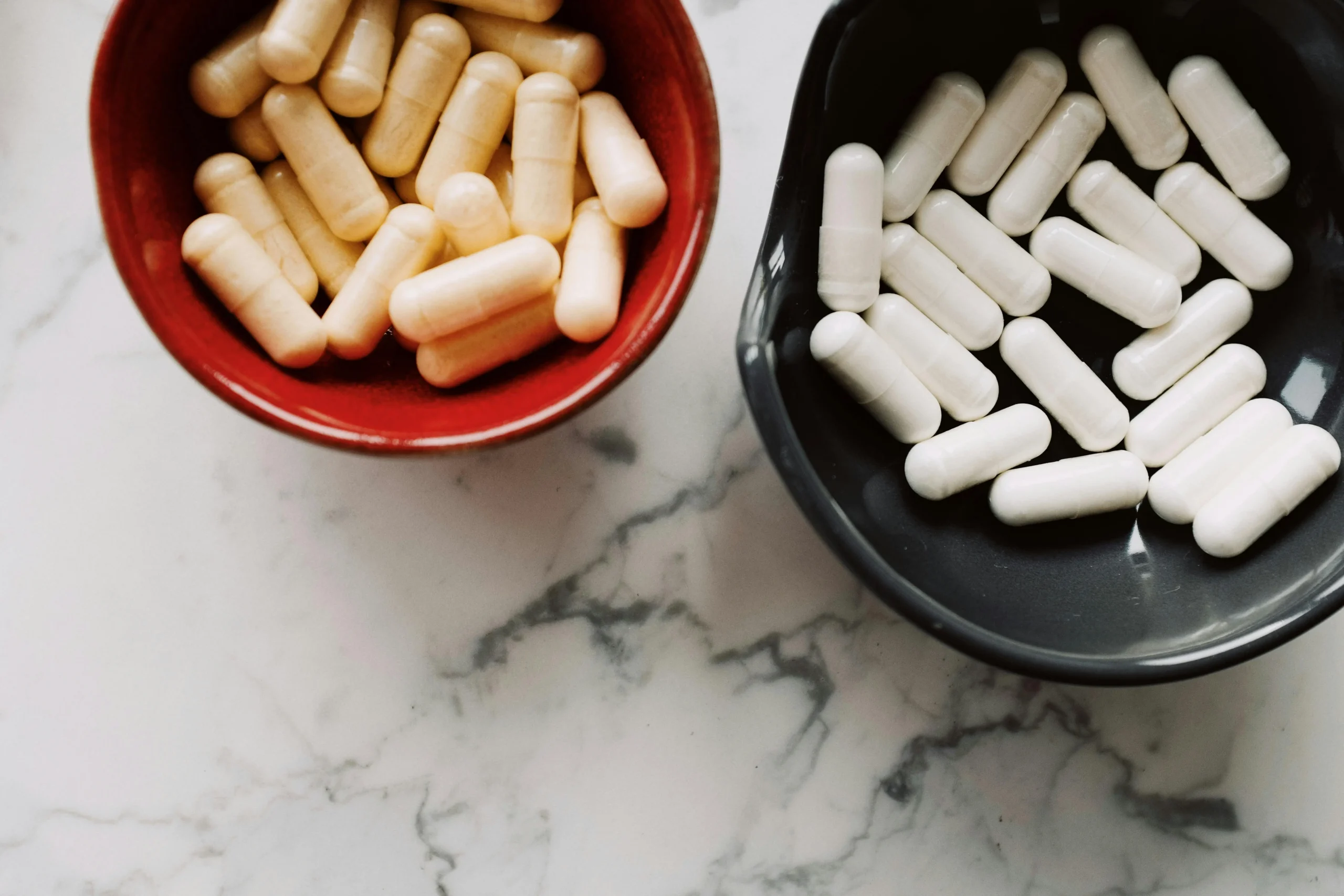 probiotic capsules with defensible CFU counts in two dishes on a marble countertop