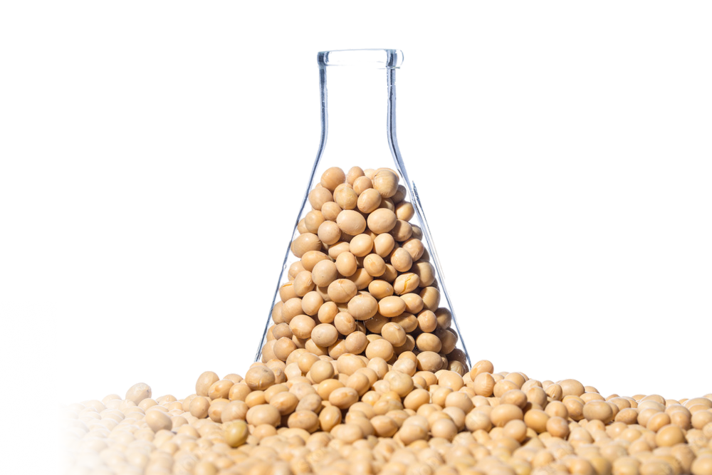 A graduated cylinder filled with nuts suggests laboratory allergen testing for tree nuts or peanuts